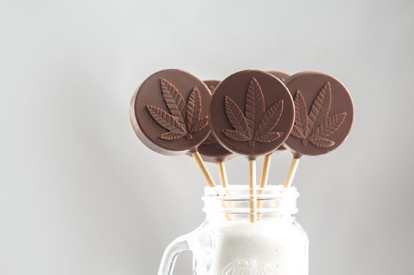 photo of cannabis edibles shaped as chocolate lollipops displayed in a glass jar